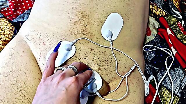 Domme Nika plays with electric discharges on the groin of the gimp. Electrostimulation BDSM